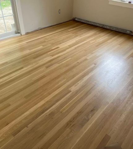 Hardwood floor in a room featuring a window that allows natural light to enter.