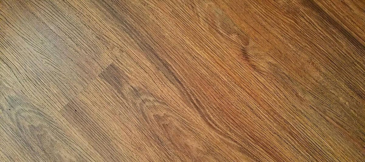 A close-up view of a brown wooden floor showcasing the rich texture and grain of the wood.